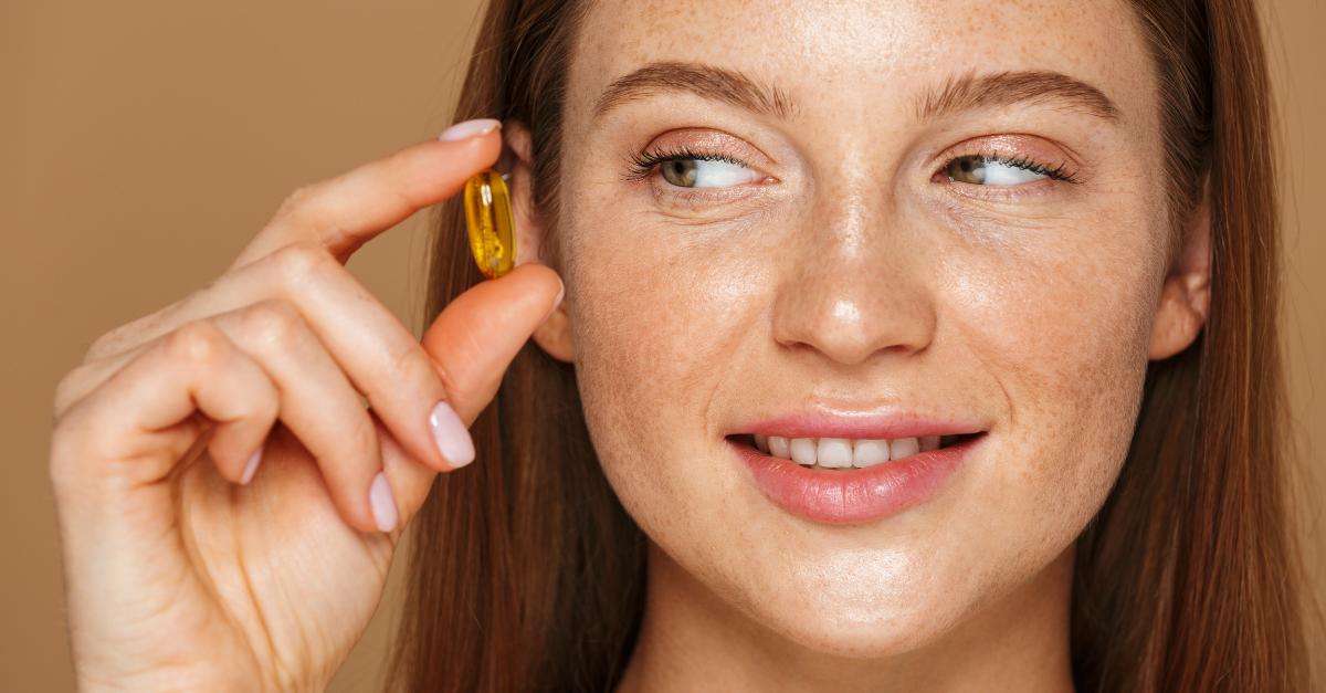 Woman holding vitamin pill 